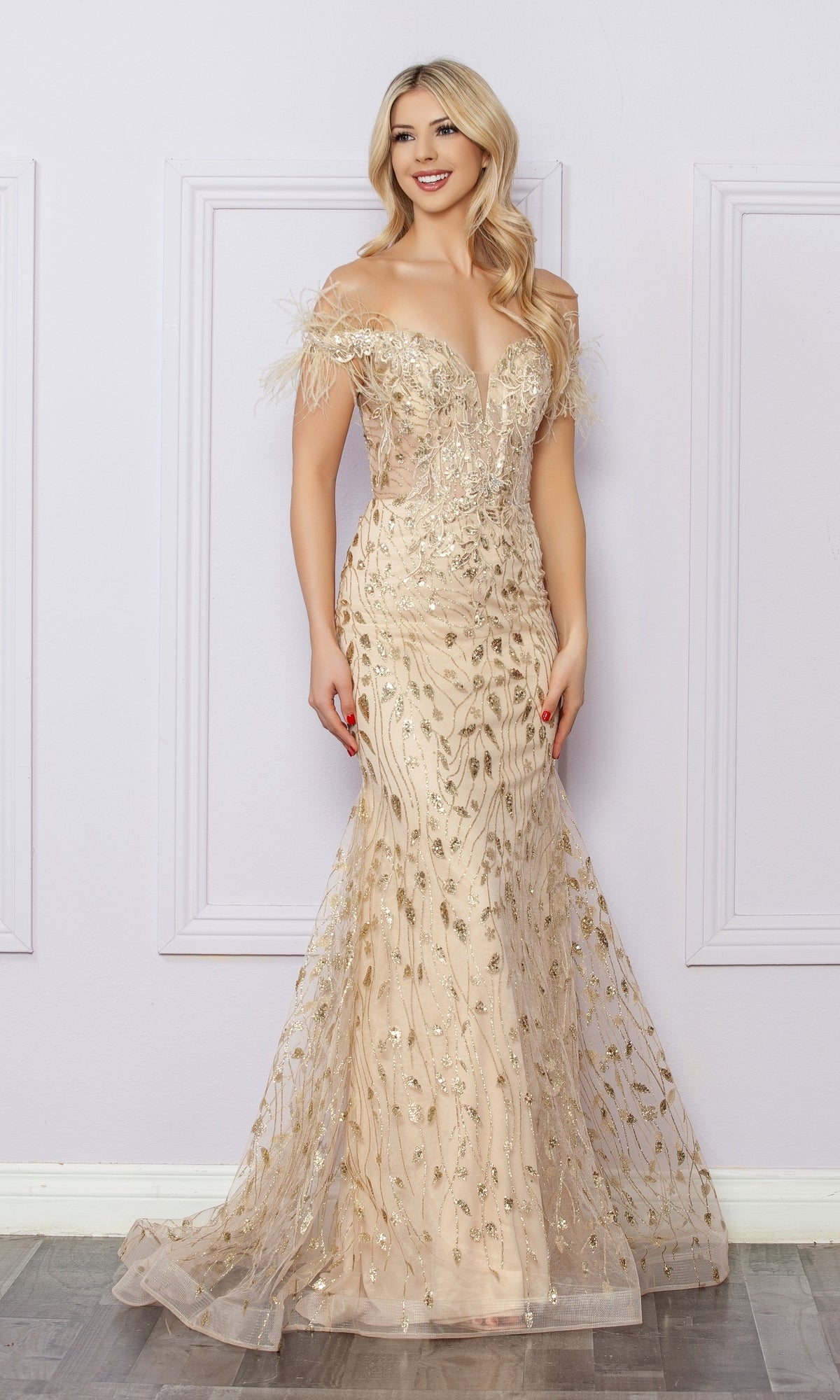 A woman poses in the Sequined Glitter-Print Prom Dress: Nox Anabel L1255, a floor-length gown with off-the-shoulder design, gold embroidery, and feather details, standing against a light purple wall.
